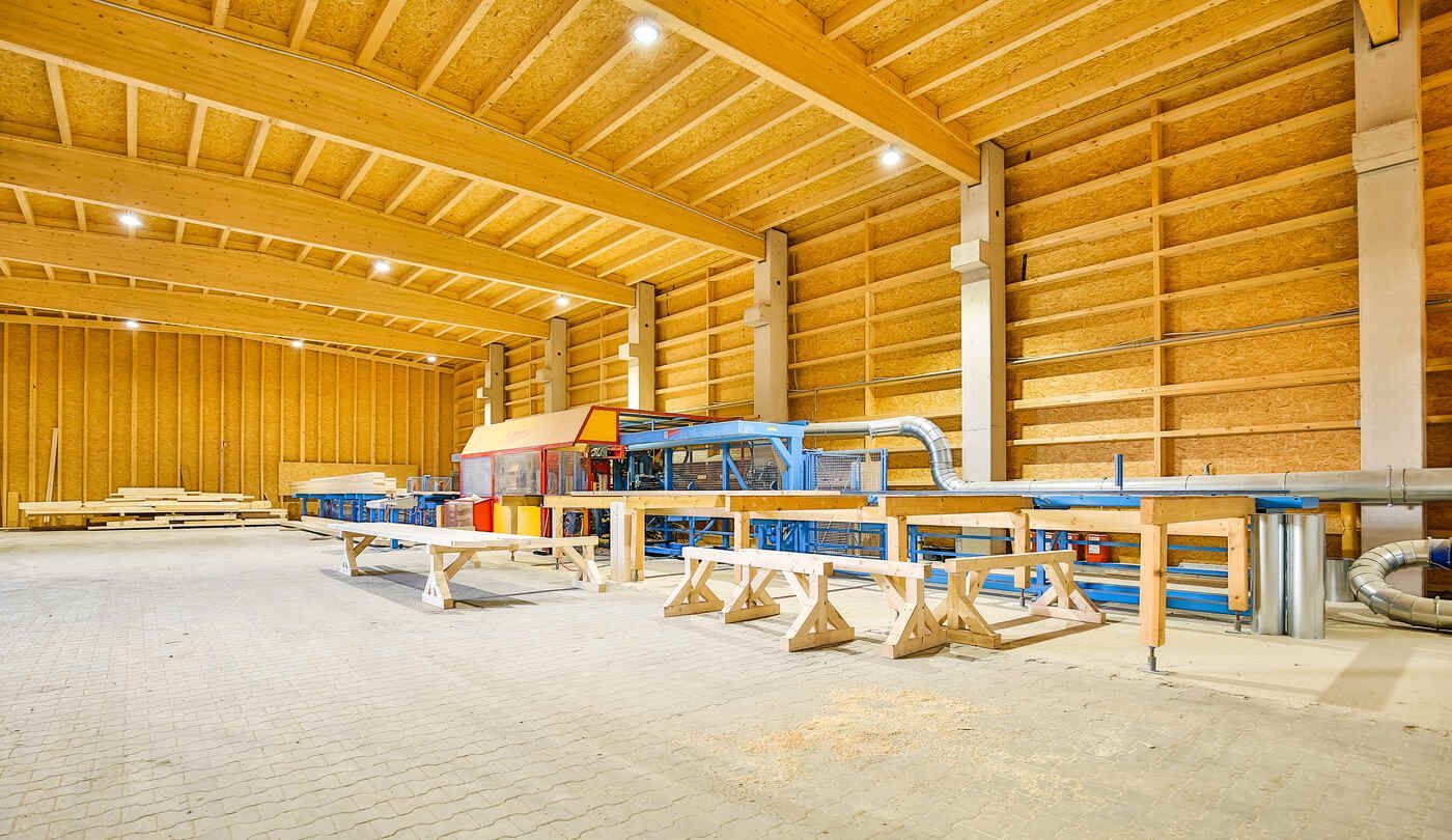 Eine große Lagerhalle aus Holz mit einer Maschine in der Mitte.