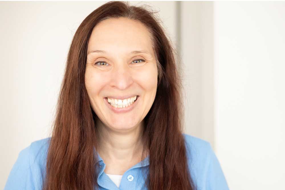 Eine Frau in einem blauen Hemd steht in einem Raum