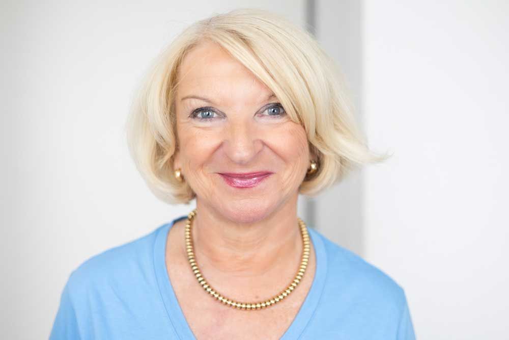 Eine Frau in einem blauen Oberteil steht in einem Raum