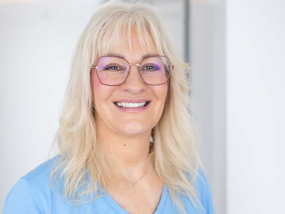 Eine Frau in einem blauen Hemd steht in einem Raum