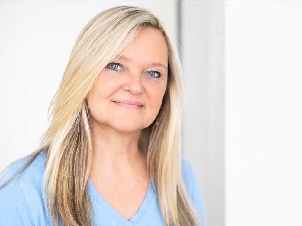 Eine Frau in einem blauen Hemd steht in einem Raum