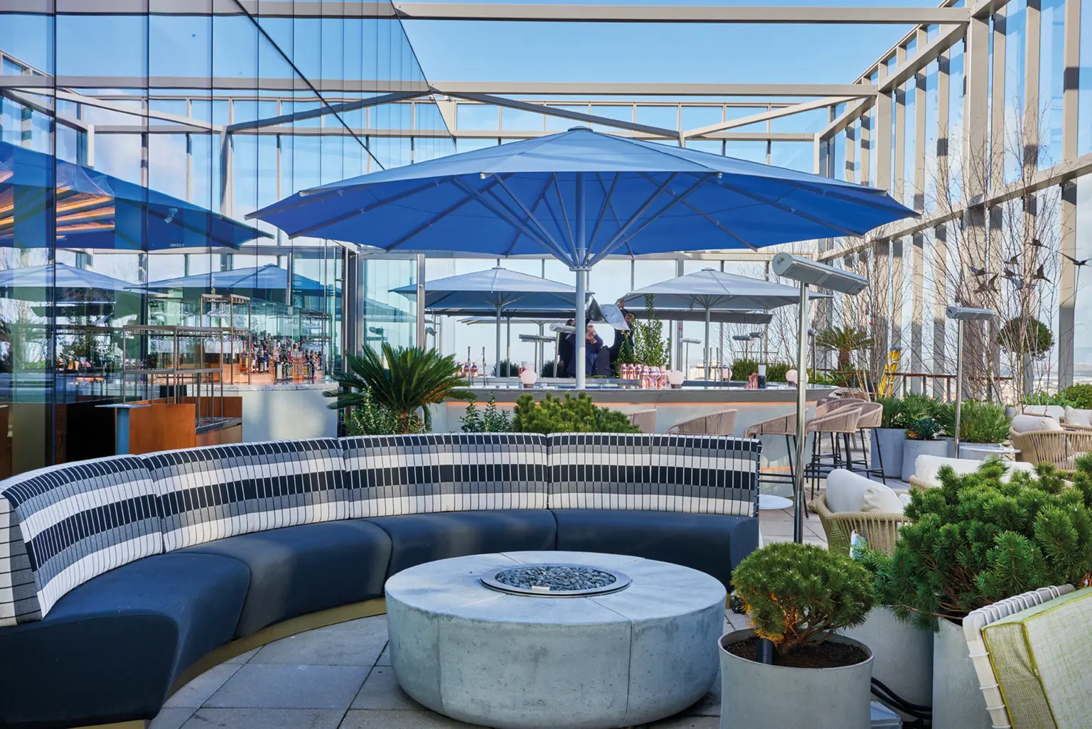 Un grand parasol bleu sur une terrasse.