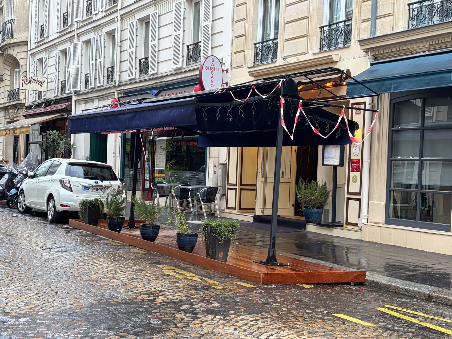 Un store de terrasse bleu et des pots.