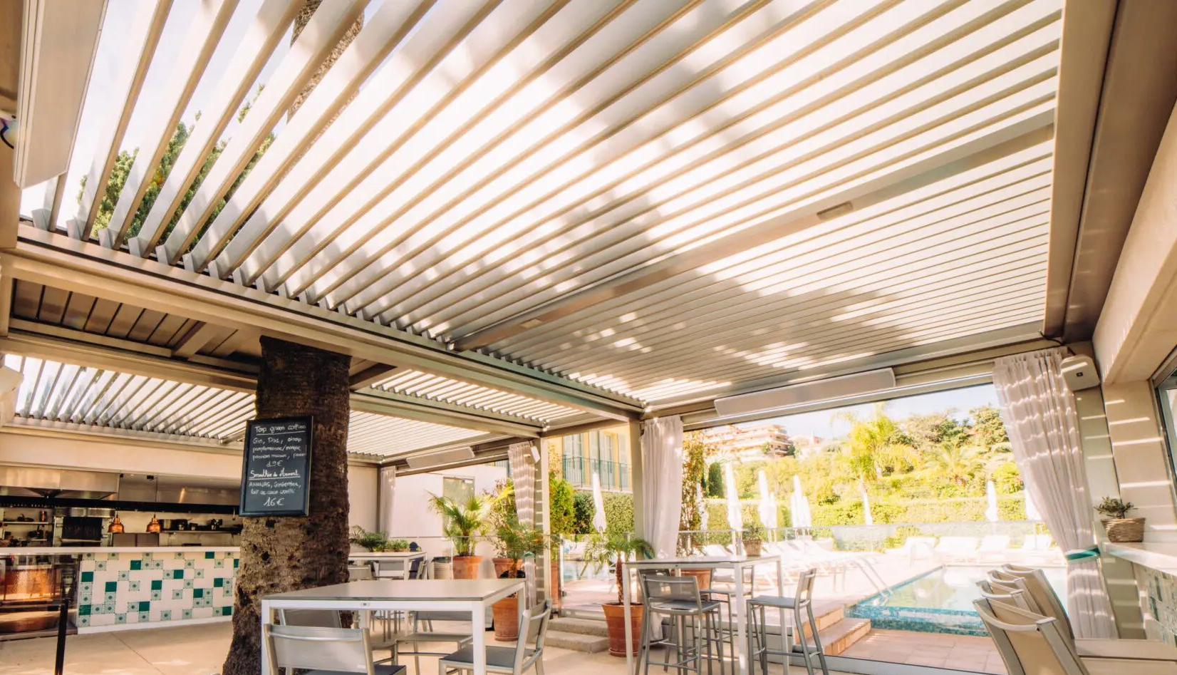 Une pergola bioclimatique au-dessus d'un bar.