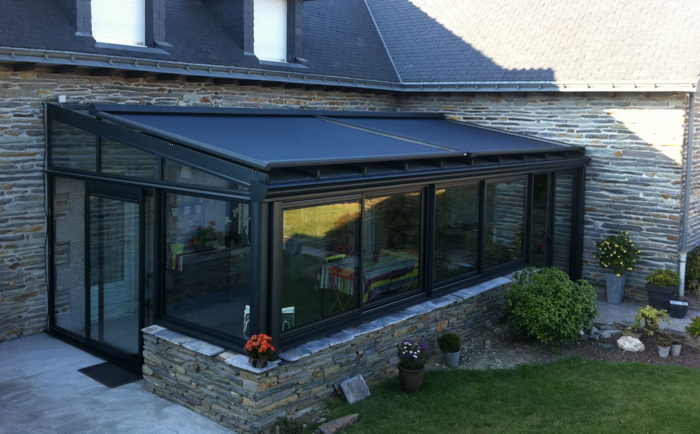 Une véranda avec un store de toiture.