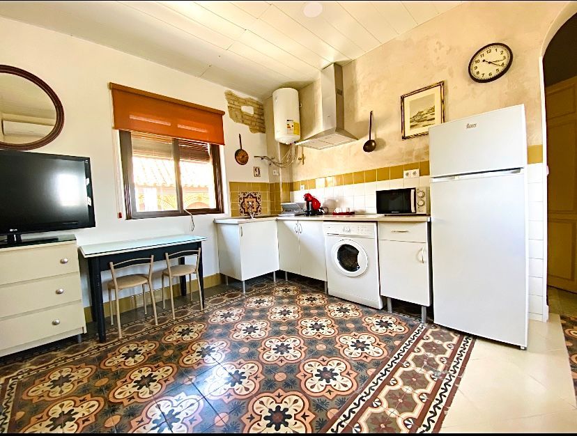 Una cocina con un reloj en la pared y una alfombra en el suelo.