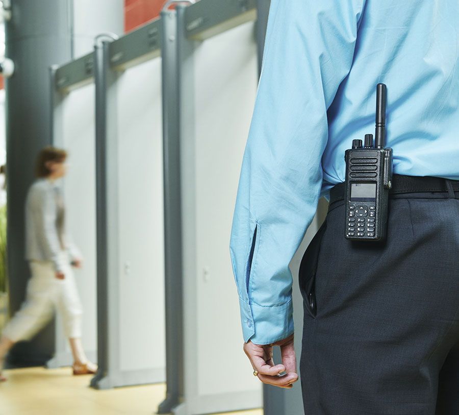 Un hombre con una camisa azul tiene un walkie talkie en su espalda