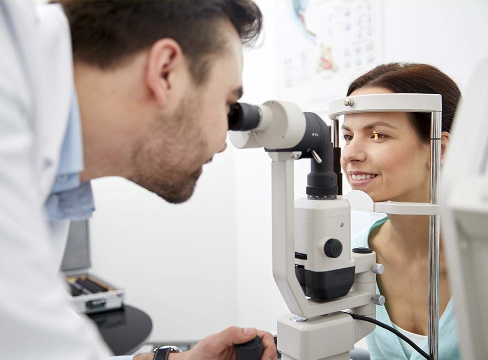 Un hombre mira a través de un microscopio el ojo de una mujer.