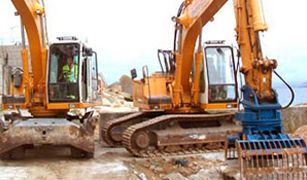 Dos excavadoras amarillas están estacionadas una al lado de la otra en un sitio de construcción.