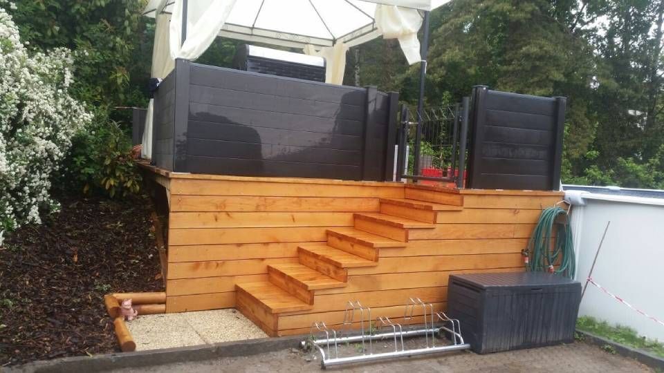Terrasse en bois dans le jardin avec marches, panneaux d'intimité noirs.
