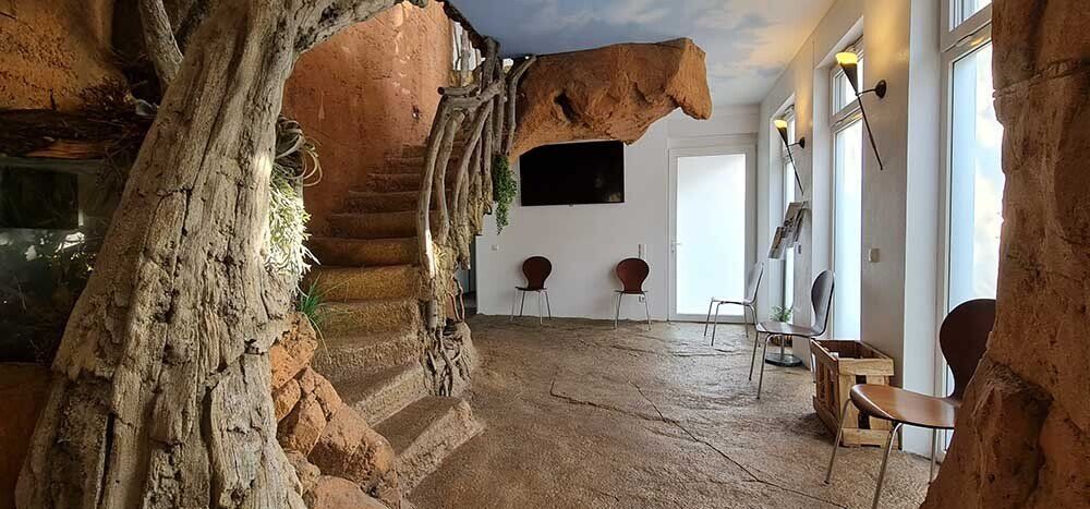 Ein Flur mit Treppen und einem Baum in der Mitte.