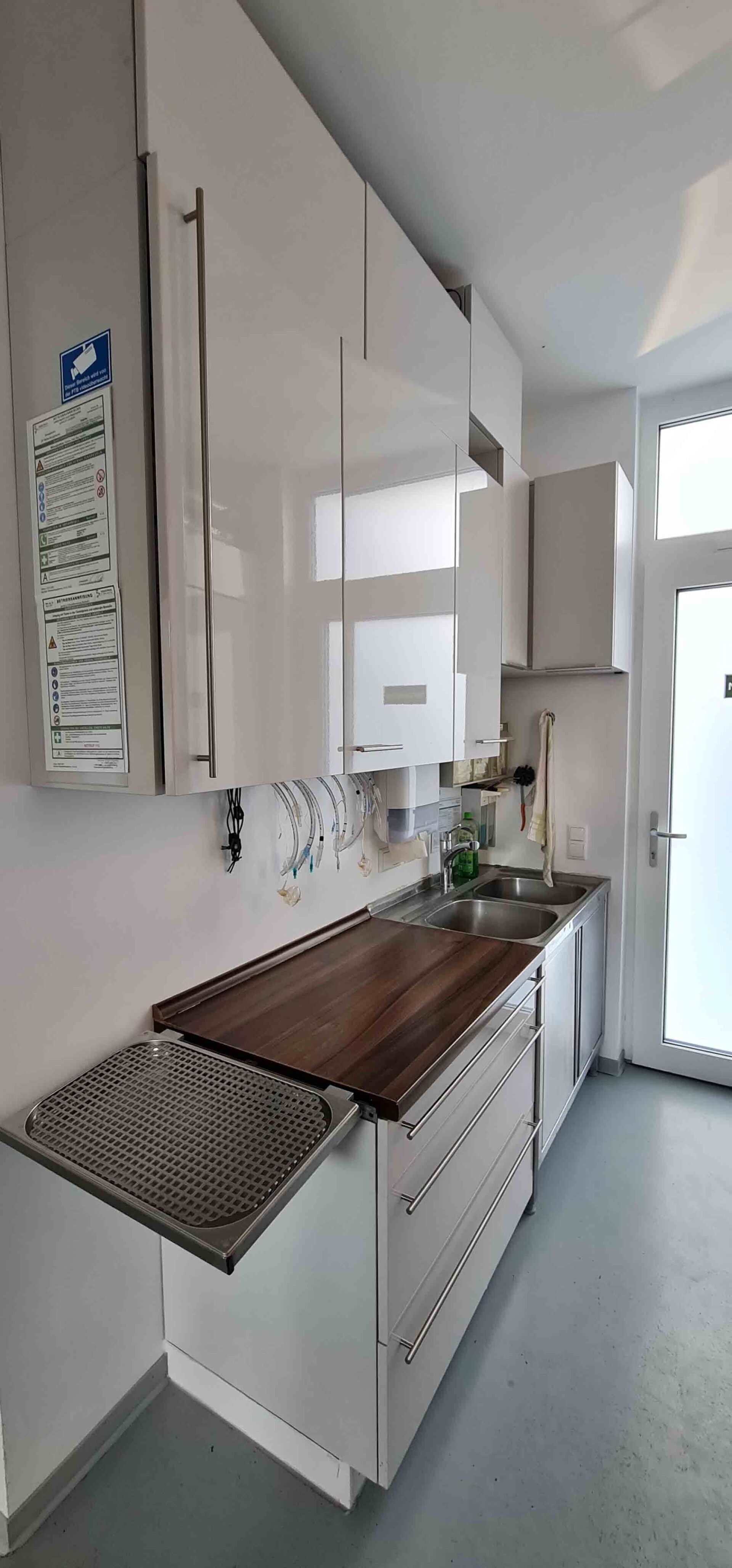 Eine Küche mit weißen Schränken und einer Arbeitsplatte aus Holz.