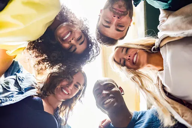 Un grupo de jóvenes está de pie en círculo mirando a la cámara.