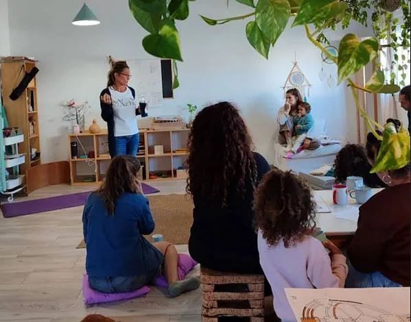Una mujer está dando una presentación a un grupo de personas en una habitación.