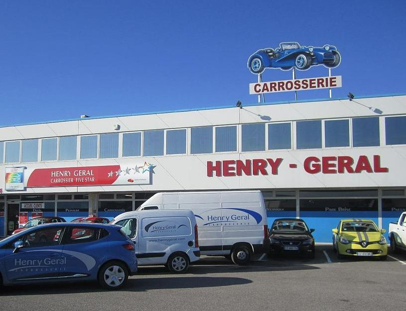 Série de voitures et d'utilitaires devant l'atelier de carrosserie Henry Géral