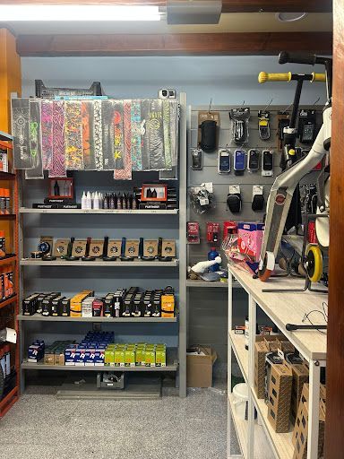 Interior de la tienda con estanterías que exhiben monopatines, ruedas, rodamientos y accesorio.