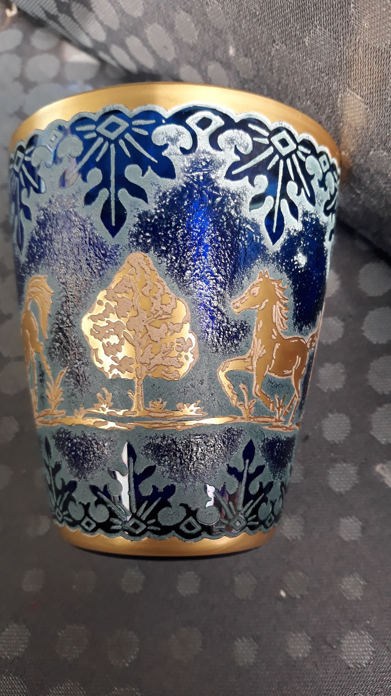 Vase ancien bleu avec des ornements dorés.