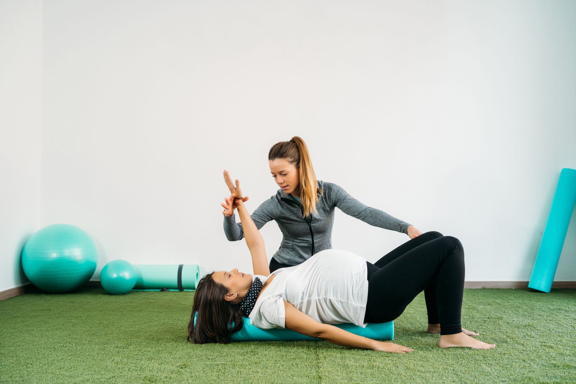 Eine Person liegt auf dem Bauch auf einer Massageliege, entlang deren Rücken mehrere Schröpfgläser angebracht sind.