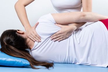 Blaues Kinesiologie-Tape wird fächerförmig über den oberen Rücken und die Schulter einer Person geklebt, um die Muskulatur zu stützen.