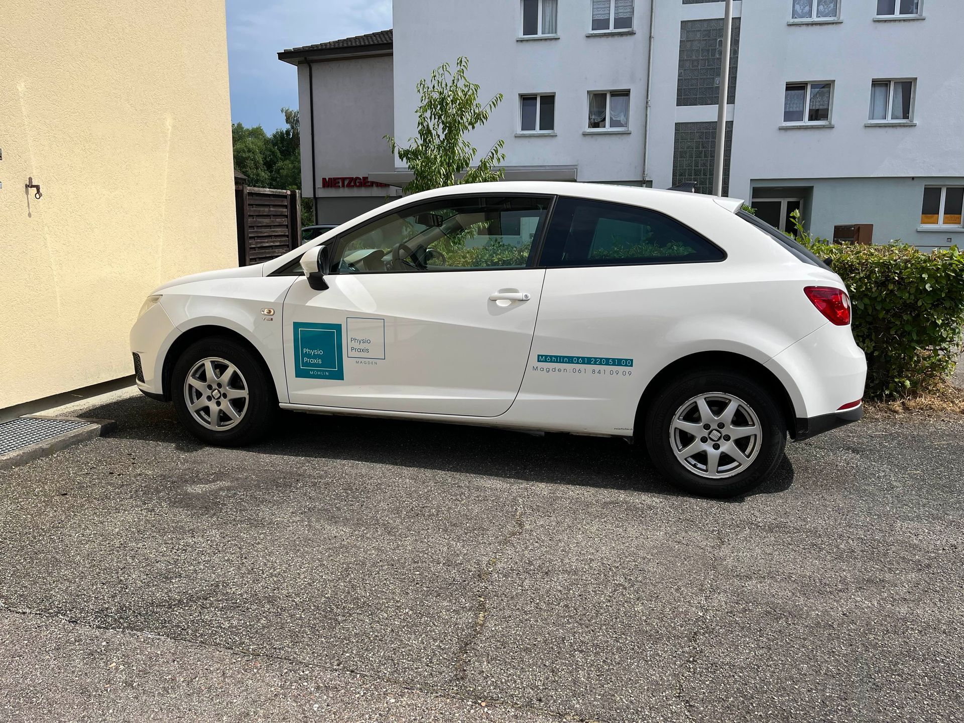 Eine Person in einem grünen Hemd massiert den Rücken einer anderen Person manuell.
