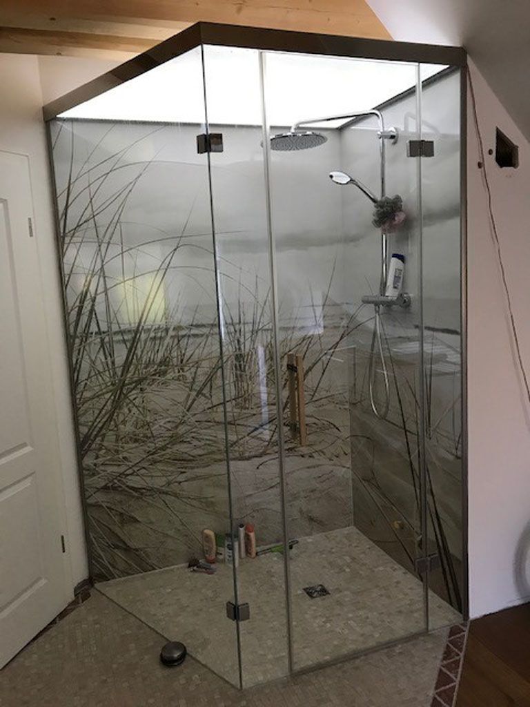 Eine Duschkabine mit einem Baumbild an der Wand.