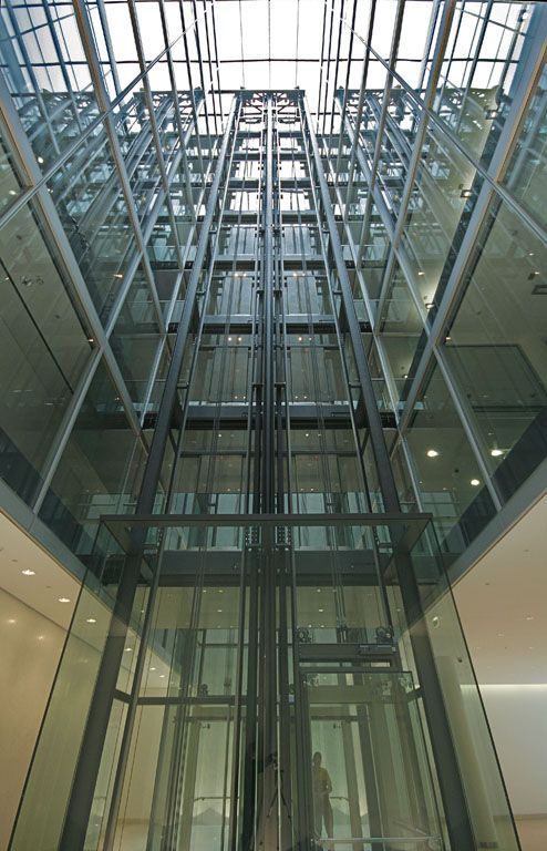 Blick nach oben auf einen Aufzug in einem Gebäude mit vielen Fenstern