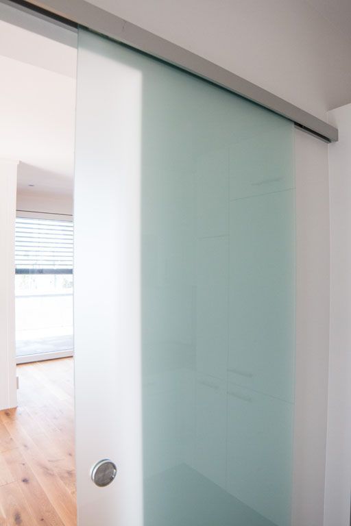 Eine Nahaufnahme einer Glasschiebetür in einem Raum.