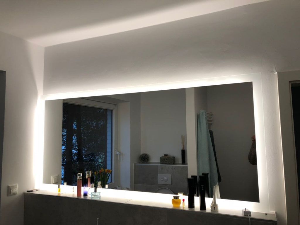 Ein Badezimmer mit einem großen, beleuchteten Spiegel