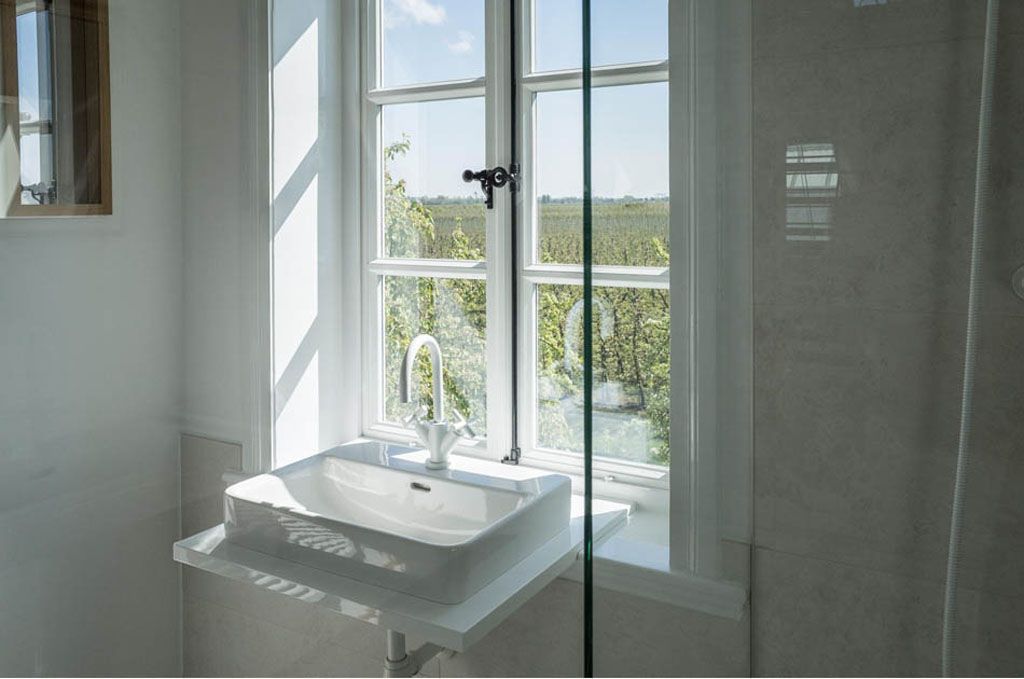 Ein Badezimmer mit Waschbecken, Dusche und Fenster.