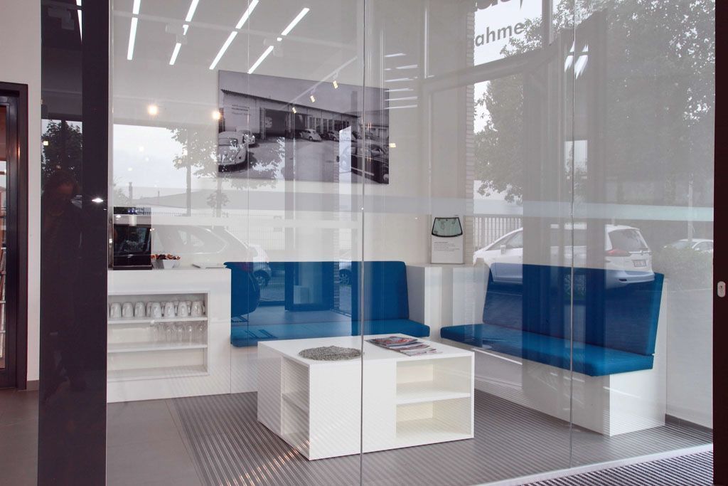 Ein Wartezimmer mit blauen Sitzen und einem Couchtisch