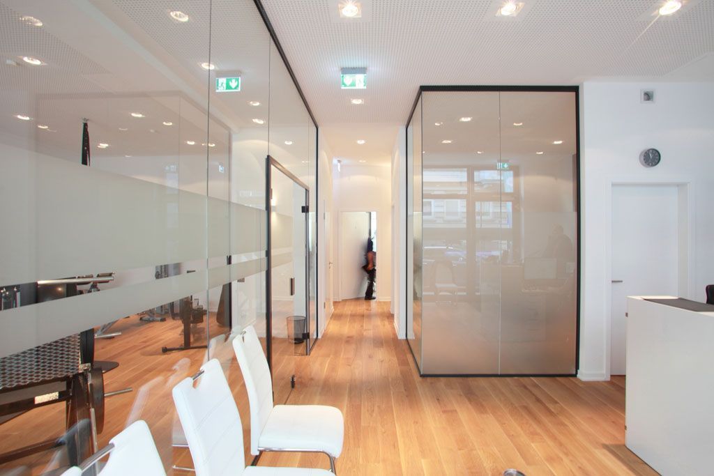 Ein Wartezimmer mit Stühlen und einer Glaswand