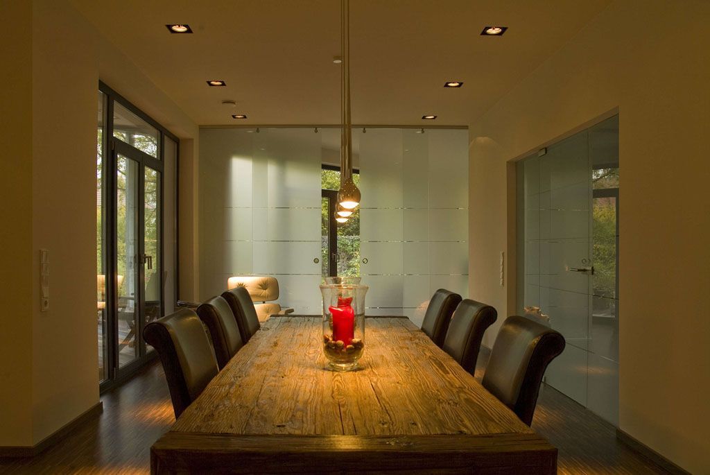 Ein Esszimmer mit einem langen Holztisch und Stühlen