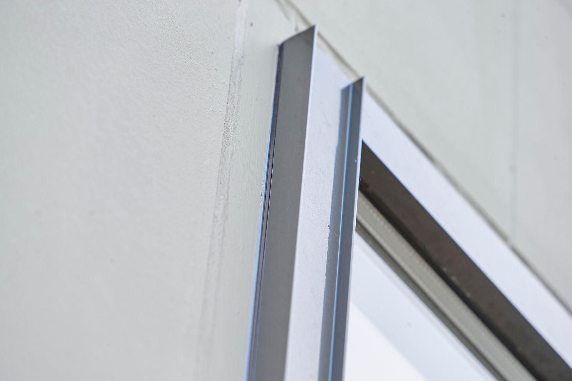 Eine Nahaufnahme einer Glasschiebetür an einer weißen Wand.