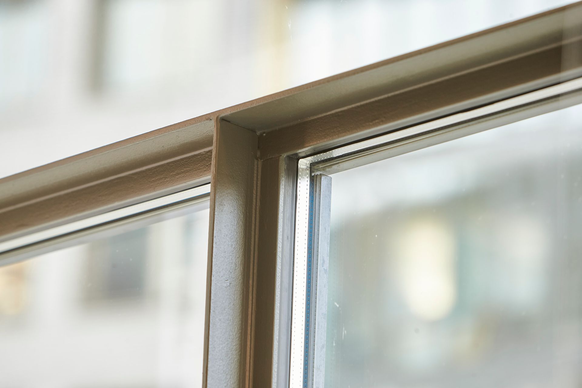 Eine Nahaufnahme eines Fensters mit Metallrahmen und Glas.