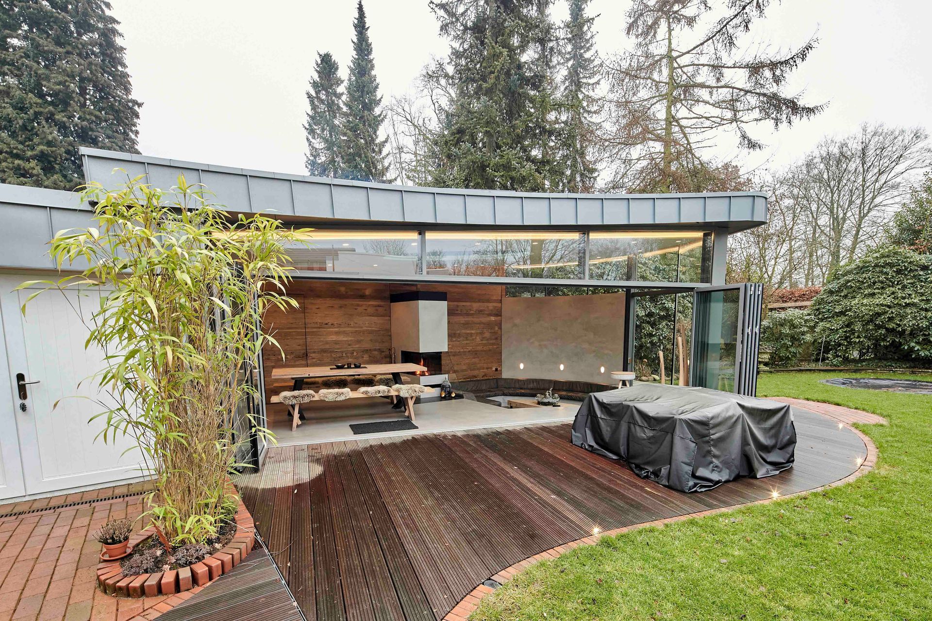 Ein Haus mit einer Terrasse und einem Whirlpool im Hinterhof.