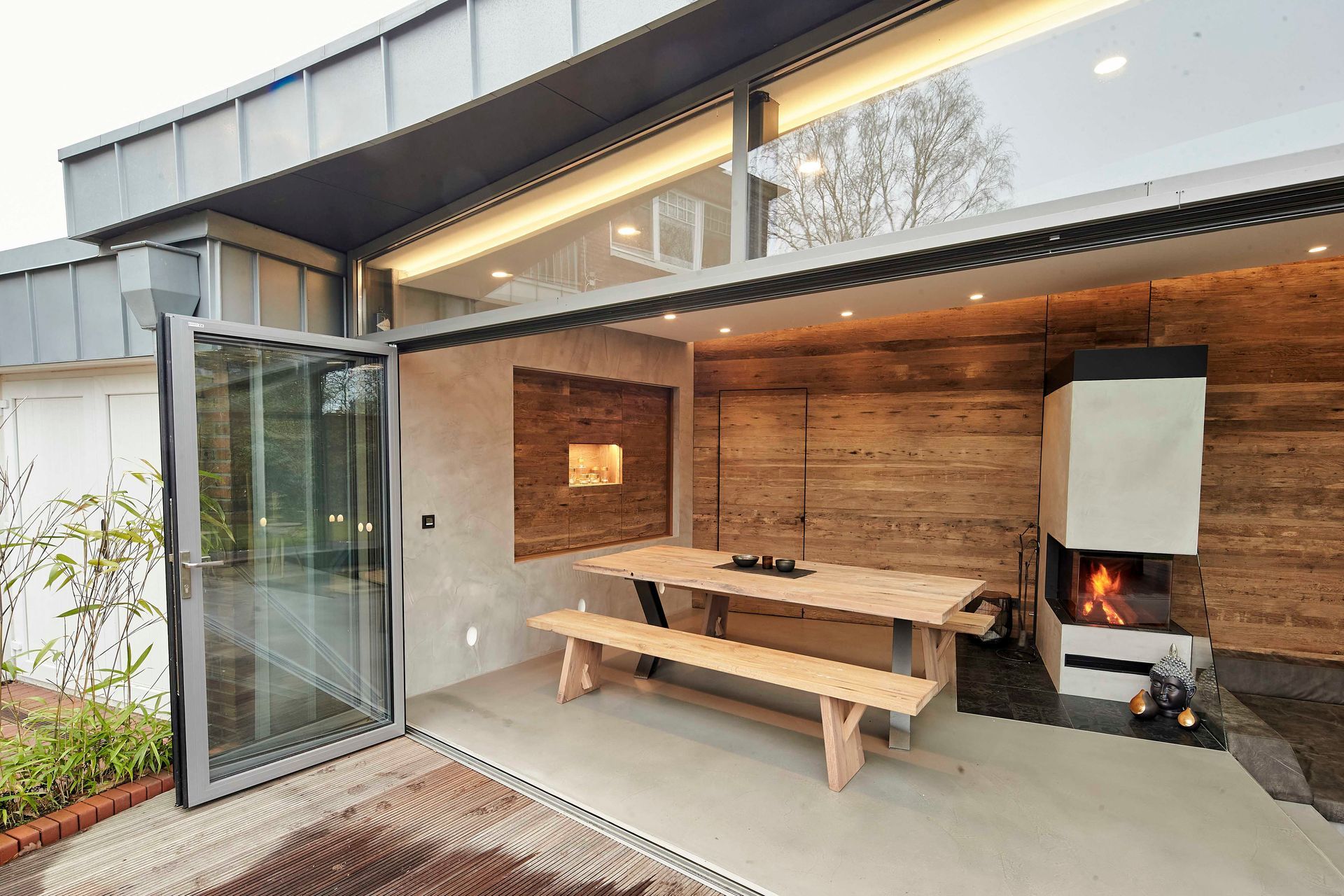 Eine Terrasse mit Tisch und Bänken sowie einer Feuerstelle.