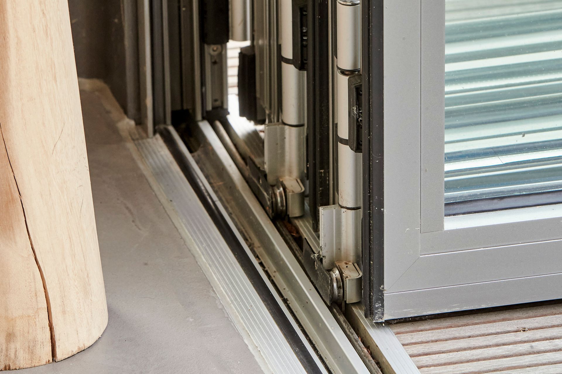 Eine Nahaufnahme einer Glasschiebetür mit einem Holzpfosten im Hintergrund