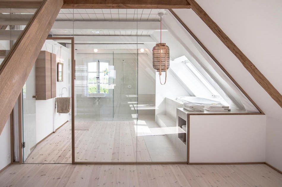 Ein Badezimmer mit Glaswand und Holztreppe