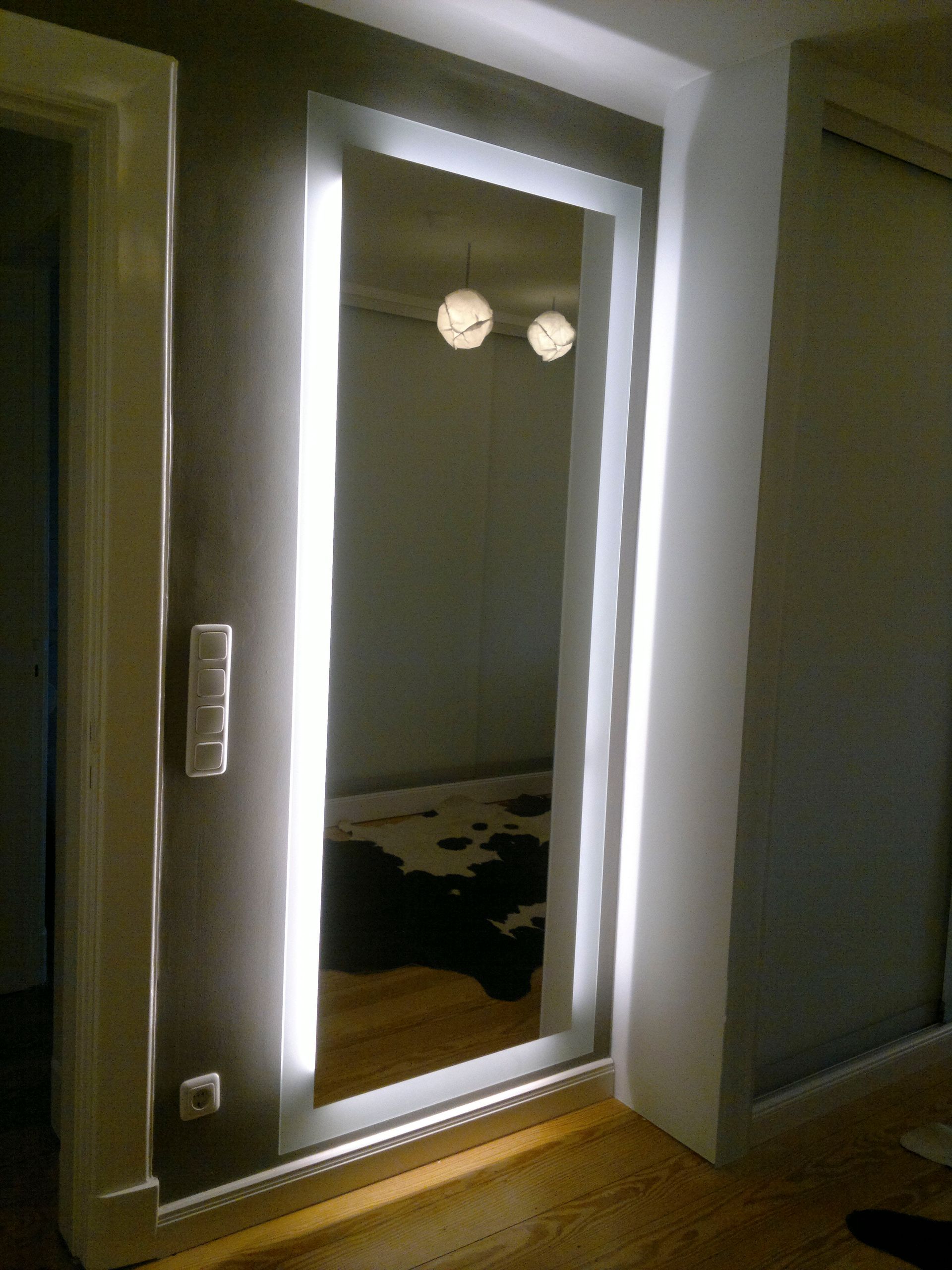 Ein Ganzkörperspiegel ist in einem Flur beleuchtet