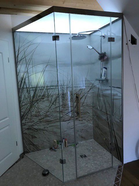 Ein Badezimmer mit ebenerdiger Dusche und einem Baumbild an der Wand