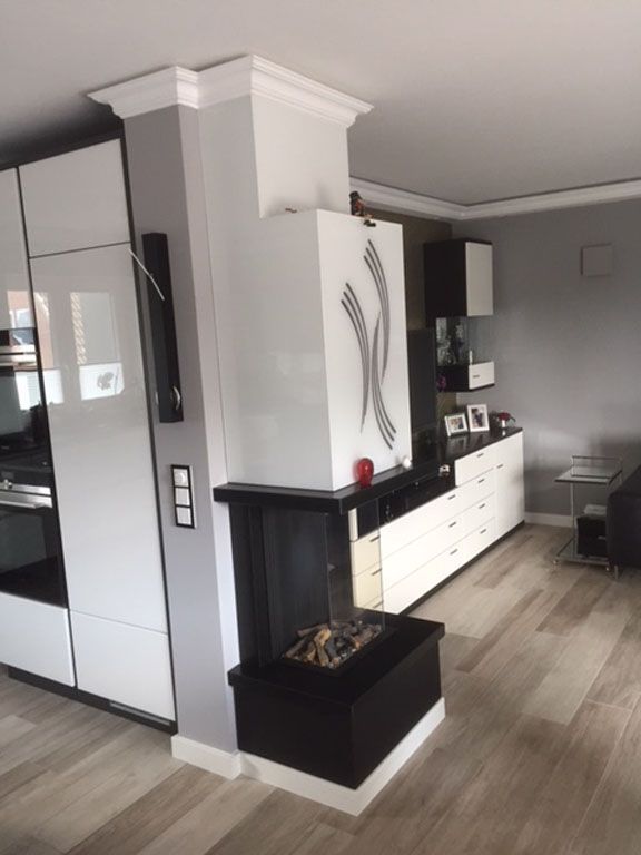 Ein Wohnzimmer mit Kamin und weißen Schränken