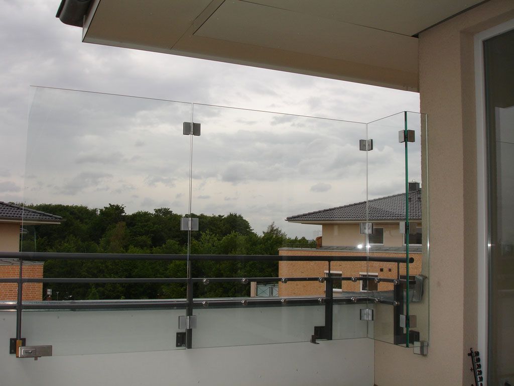 Ein Balkon mit Blick auf ein Haus und Bäume