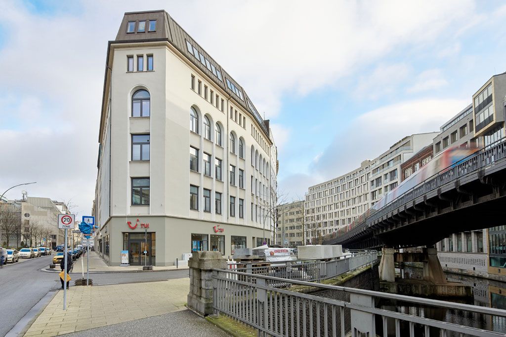 Ein großes weißes Gebäude mit einer Brücke im Hintergrund