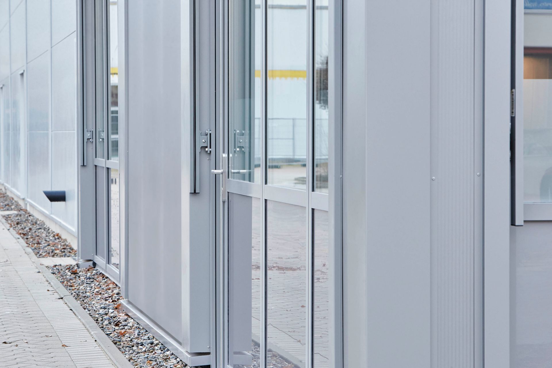 Ein weißes Gebäude mit vielen Fenstern und Türen.