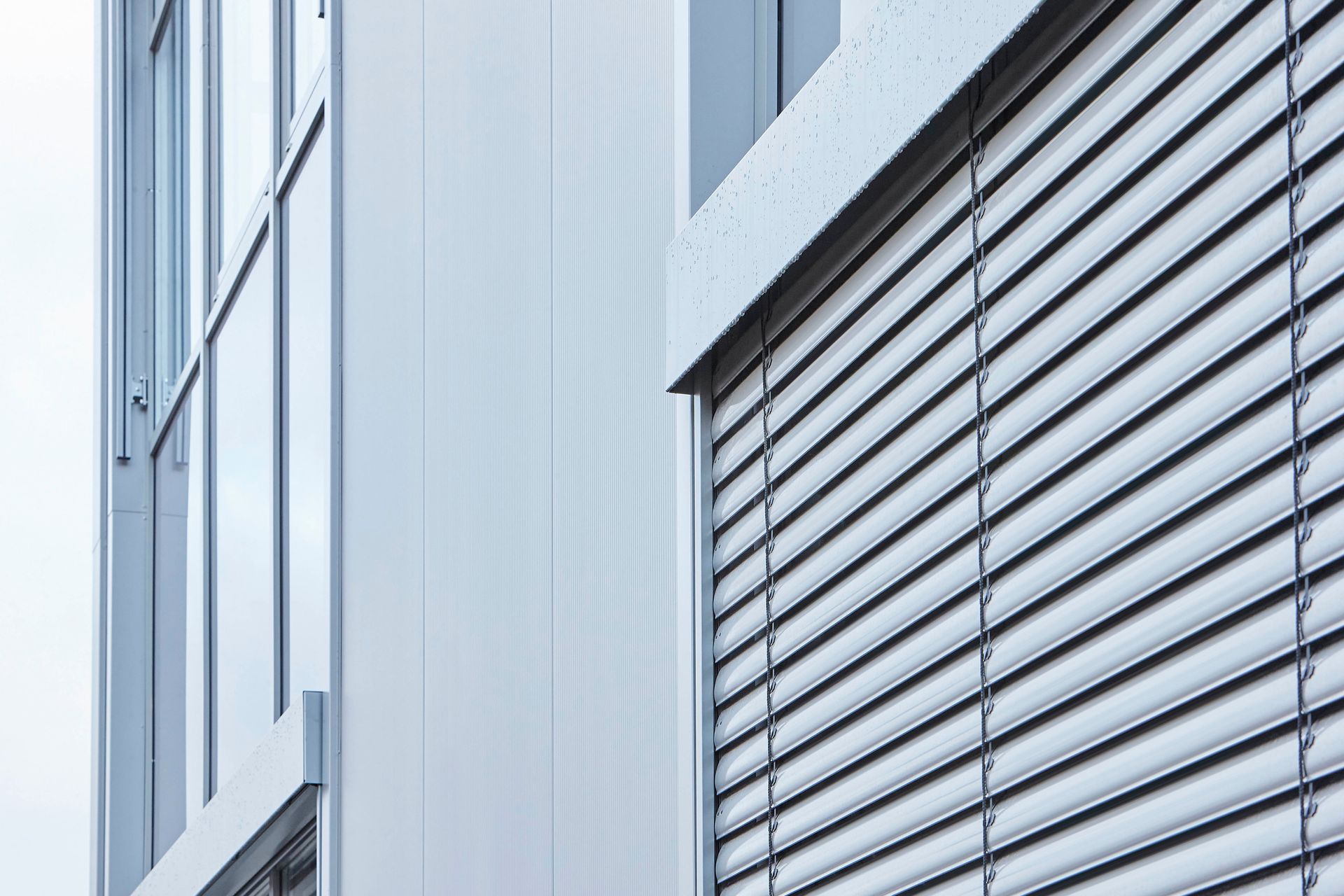 Ein Gebäude mit vielen Fenstern und Jalousien.