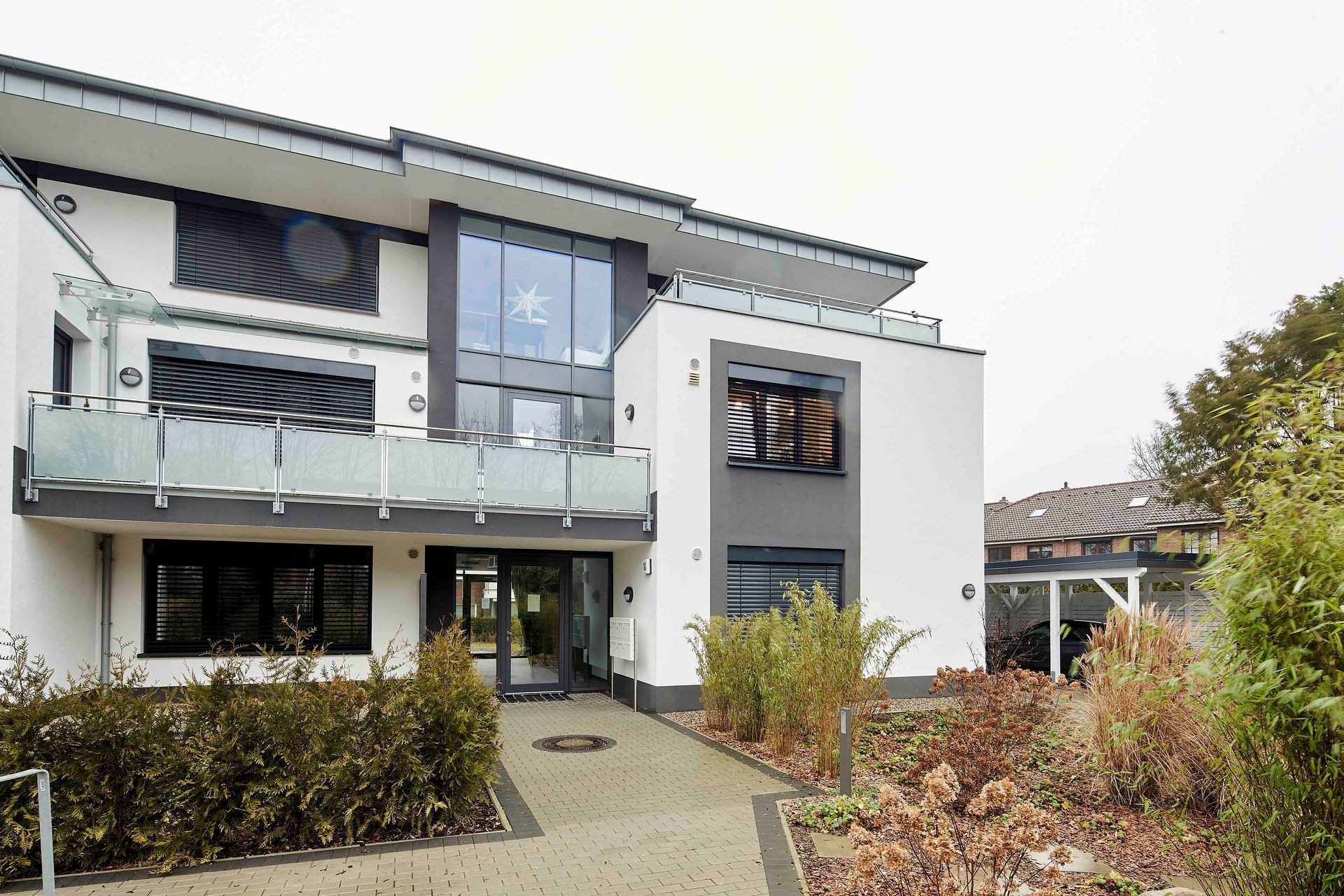 Ein großes weißes Haus mit einem Balkon und vielen Fenstern