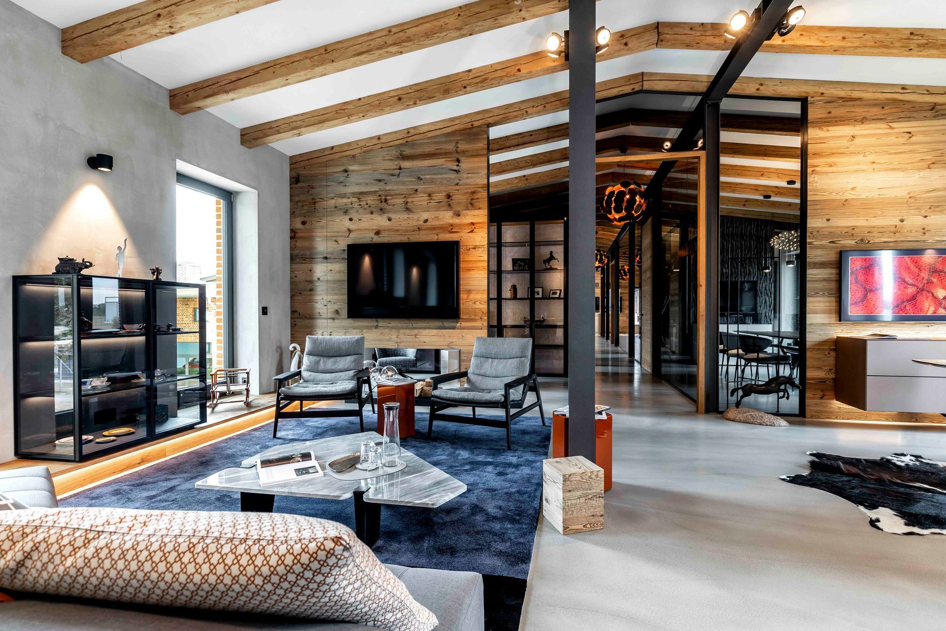 Ein Wohnzimmer mit einer Couch, Stühlen, einem Tisch und einem Fernseher.