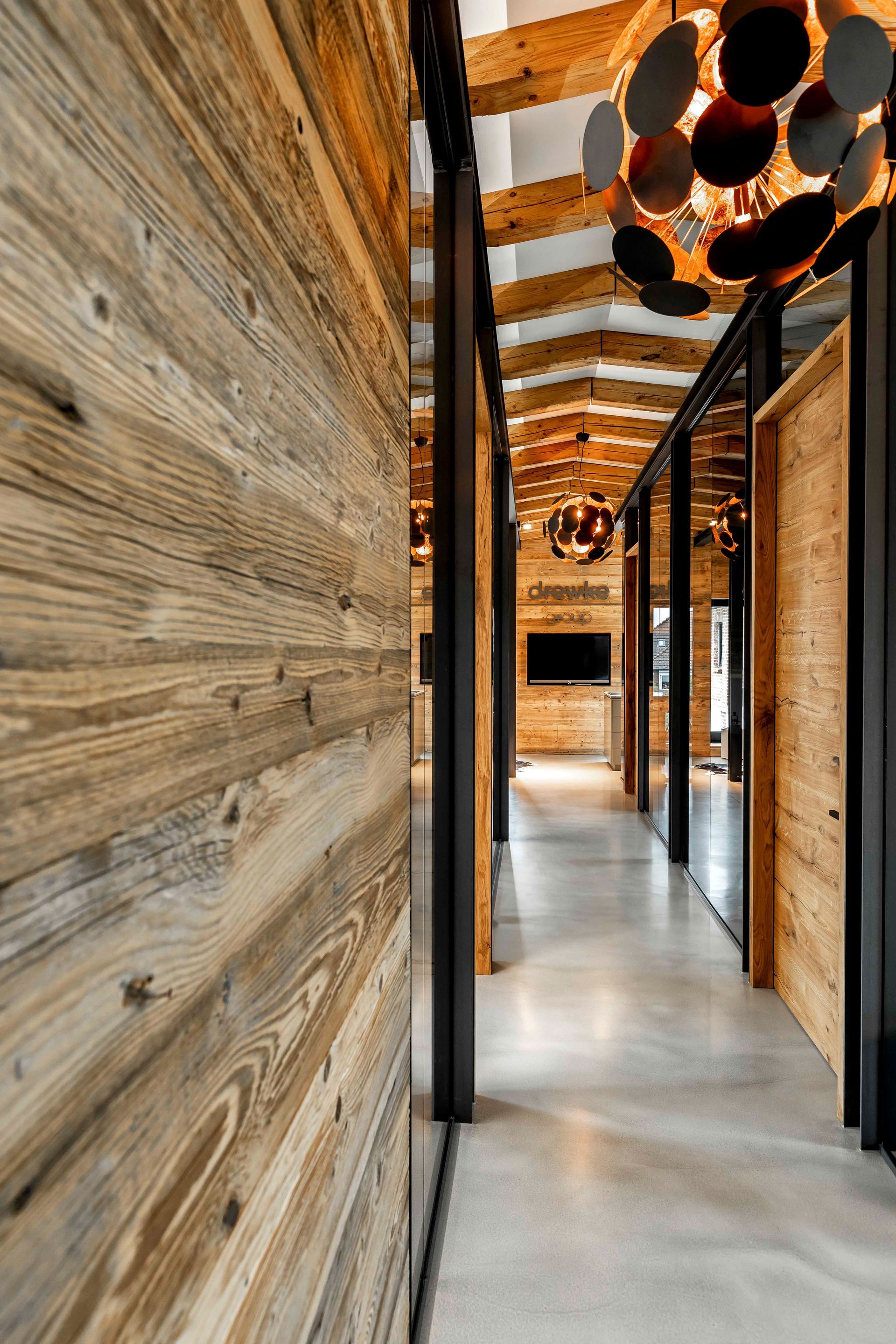 Ein Flur mit Holzwänden und einem Kronleuchter, der von der Decke hängt.