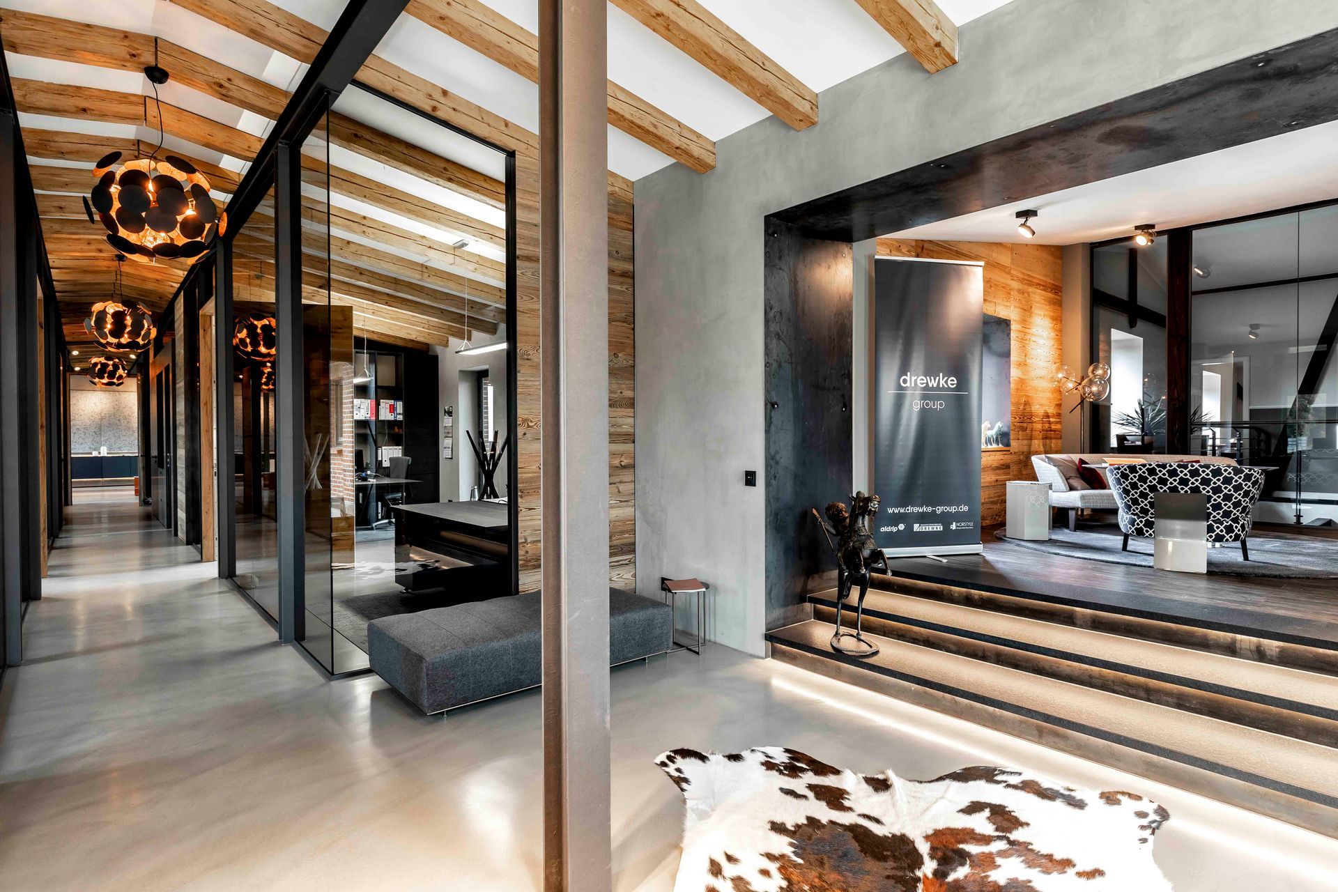 In der Mitte des Zimmers liegt ein Teppich mit Kuhfellmuster.