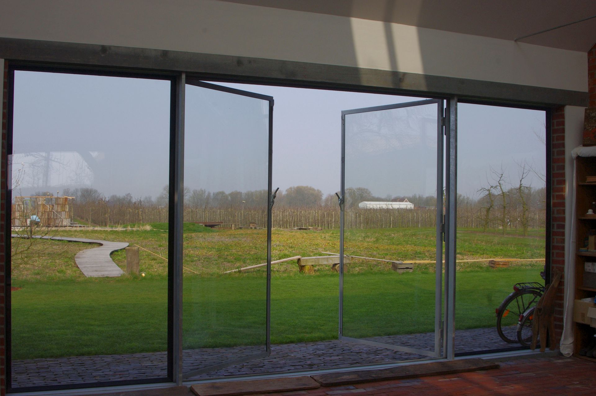 Vor einer großen Glastür ist ein Fahrrad abgestellt.